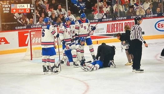 Team USA defenseman Cole Hutson being attended to by medical staff after suffering an injury at World Junior Championships.