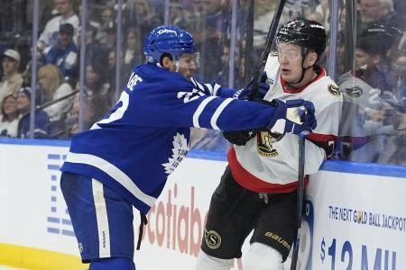 Dec 27, 2025; Toronto, Ontario, CAN; Toronto Maple Leafs defenseman Jake McCabe (22) checks Ottawa Senators forward Brady Tkachuk (7) into the boards during the second period at Scotiabank Arena. Mandatory Credit: John E. Sokolowski-Imagn Images