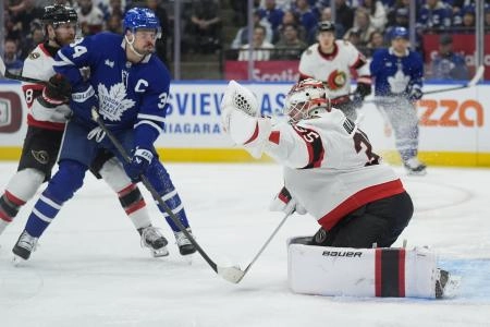 Dec 27, 2025; Toronto, Ontario, CAN; Ottawa Senators goaltender Linus Ullmark (35) makes a glove save as Toronto Maple Leafs forward Auston Matthews (34) closes in during the first period at Scotiabank Arena.