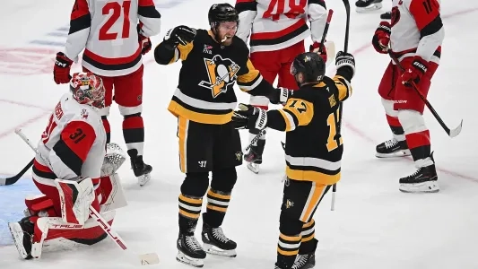Pittsburgh Penguins players celebrate a goal around Carolina Hurricanes players