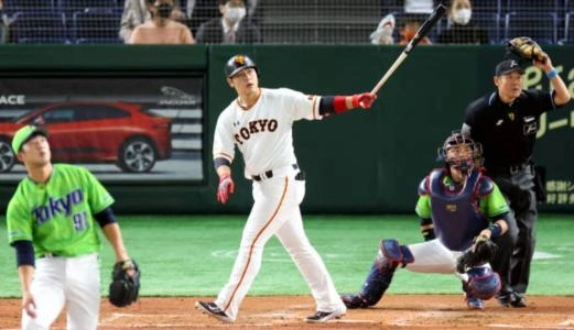 Yomiuri Giants third baseman Kazuma Okamoto hits a home run at the Tokyo Dome in Japan.