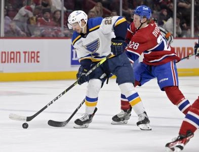 7 janvier 2023; Montr&eacute;al, Qu&eacute;bec, Canada; L'attaquant des Blues de St. Louis, Jordan Kyrou (25), joue la rondelle contre l'attaquant des Canadiens de Montr&eacute;al, Christian Dvorak (28), durant la premi&egrave;re p&eacute;riode au Centre Bell.