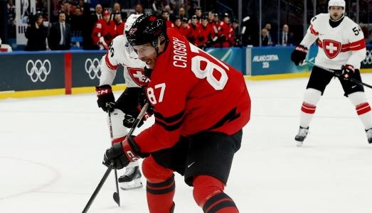 Feb 13, 2026; Milan, Italy; Sidney Crosby of Canada in action with Akira Schmid of Switzerland in men's ice hockey group A play during the Milano Cortina 2026 Olympic Winter Games at Milano Santagiulia Ice Hockey Arena. Mandatory Credit: Geoff Burke-Imagn Images