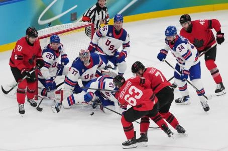 22 f&eacute;vrier 2026 ; Milan, Italie ; Dylan Larkin et Connor Hellebuyck (&Eacute;tats-Unis) se disputent le palet face &agrave; Devon Toews (Canada) lors de la finale du tournoi de hockey sur glace masculin des Jeux olympiques d'hiver de Milan-Cortina 2026, &agrave; la patinoire de Milan-Santagiulia.