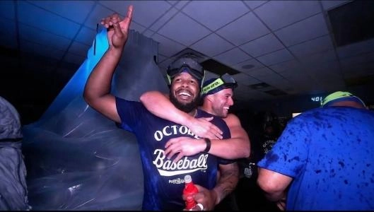 September, 2025: Toronto Blue Jays designated hitter George Springer (4) celebrates with first baseman Vladimir Guerrero Jr. (27) in the visitors clubhouse at Kauffman Stadium after clinching a playoff birth.