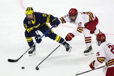 11 avril 2024 ; Saint Paul, Minnesota, &Eacute;tats-Unis ; l'attaquant des Wolverines du Michigan, T.J. Hughes (13), effectue une passe tandis que le d&eacute;fenseur des Eagles de Boston College, Aram Minnetian (17), d&eacute;fend lors de la deuxi&egrave;me p&eacute;riode des demi-finales du Frozen Four 2024, tournoi universitaire de hockey sur glace, au Xcel Energy Center.