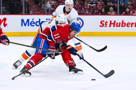 21 mars 2026; Montr&eacute;al, Qu&eacute;bec, Canada; l'ailier droit des Canadiens de Montr&eacute;al, Brendan Gallagher (11), joue la rondelle contre le d&eacute;fenseur des Islanders de New York, Ryan Pulock (6), durant la premi&egrave;re p&eacute;riode au Centre Bell.