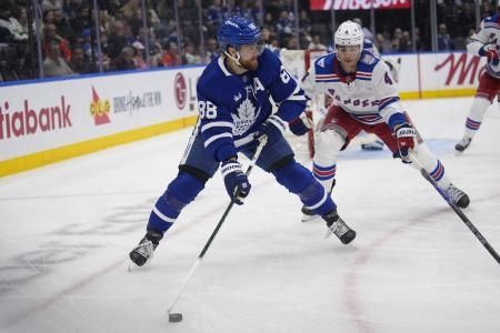 Mar 25, 2026; Toronto, Ontario, CAN; Toronto Maple Leafs forward William Nylander (88) goes to pass the puck as New York Rangers defenseman Braden Schneider (4) closes in during the third period at Scotiabank Arena.
