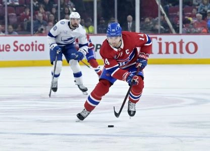 9 f�vrier 2025; Montr�al, Qu�bec, Canada; L'attaquant des Canadiens de Montr�al, Nick Suzuki (14), contr�le la rondelle durant la deuxi�me p�riode du match contre le Lightning de Tampa Bay au Centre Bell.