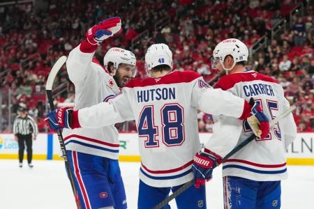 Jan 1, 2026; Raleigh, North Carolina, USA; MontrÈal Canadiens defenseman Lane Hutson (48) celebrates his empty net goal with center Phillip Danault (24) and defenseman Alexandre Carrier (45) against the Carolina Hurricanes during the third period at Lenovo Center.