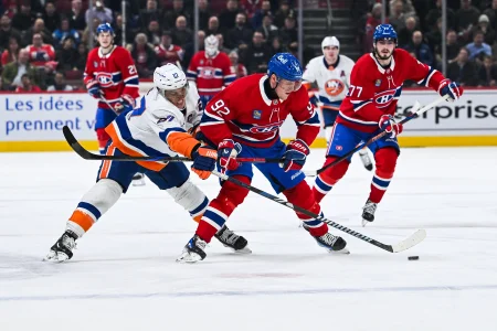 3 d�cembre 2024; Montr�al, Qu�bec, Canada; l'ailier droit des Canadiens de Montr�al, Patrik Laine (92), joue la rondelle contre l'ailier gauche des Islanders de New York, Anders Lee (27), durant la troisi�me p�riode au Centre Bell.