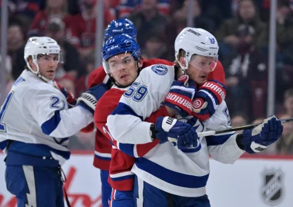 9 avril 2026; Montr�al, Qu�bec, Canada; lattaquant des Canadiens de Montr�al, Jake Evans (71), retient lattaquant du Lightning de Tampa Bay, Jake Guentzel (59), durant la premi�re p�riode au Centre Bell.