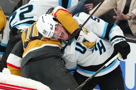 Apr 19, 2026; Las Vegas, Nevada, USA; Vegas Golden Knights center Colton Sissons (10) holds Utah Mammoth defenseman Sean Durzi (50) behind the Mammoth net during the third period of game one of the first round of the 2026 Stanley Cup Playoffs at T-Mobile Arena. Mandatory Credit: Stephen R. Sylvanie-Imagn Images