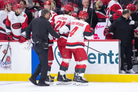 Apr 25, 2026; Ottawa, Ontario, CAN; Carolina Hurricanes defenseman Alexander Nikishin (21) is escorted off the ice after being checked in the second period against the Ottawa Senators in game four of the first round of the 2026 Stanley Cup Playoffs at the Canadian Tire Centre.