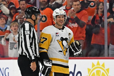 Apr 22, 2026; Philadelphia, Pennsylvania, USA; Pittsburgh Penguins center Sidney Crosby (87) is escorted to the penalty box by linesman Jonny Murray (95) against the Philadelphia Flyers during the second period in game three of the first round of the 2026 Stanley Cup Playoffs at Xfinity Mobile Arena.