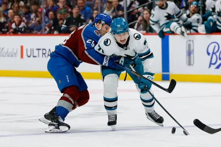 Feb 4, 2026; Denver, Colorado, USA; Colorado Avalanche center Nathan MacKinnon (29) pushes San Jose Sharks center MacKlin Celebrini (71) off the puck in the third period at Ball Arena.