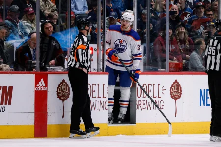 Feb 19, 2023; Denver, Colorado, USA; Edmonton Oilers left wing Warren Foegele (37) argues with referee Eric Furlatt (27) after receiving a penalty in the first period against the Colorado Avalanche at Ball Arena.