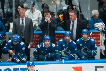 Nov 11, 2025; Vancouver, British Columbia, CAN; Vancouver Canucks assistant coach Kevin Dean and assistant coach Brett McLean and head coach Adam Foote on the bench with forward Kiefer Sherwood (44) and forward Linus Karlsson (94) and forward Arshdeep Bains (13) and forward Max Sasson (63) against the Winnipeg Jets in the third period at Rogers Arena.