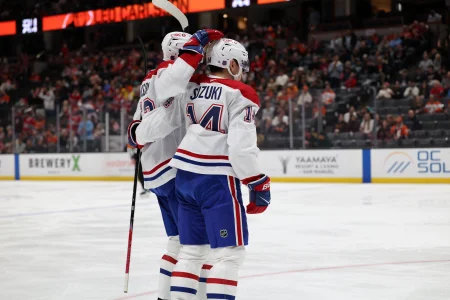 Mar 6, 2026; Anaheim, California, USA; Montreal Canadiens center Nick Suzuki (14) celebrates with defenseman Noah Dobson (left) after scoring a goal against the Anaheim Ducks during the first period at Honda Center.