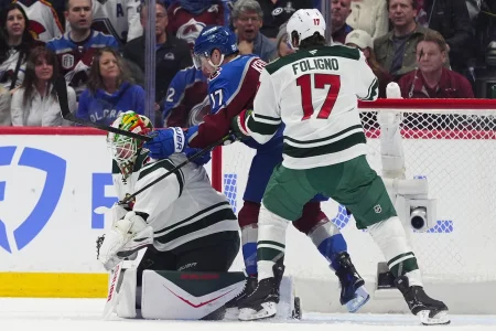 May 3, 2026; Denver, Colorado, USA; Colorado Avalanche center Parker Kelly (17) and Minnesota Wild goaltender Jesper Wallstedt (30) and left wing Marcus Foligno (17) during the first period in game one of the second round of the 2026 Stanley Cup Playoffs at Ball Arena. Mandatory Credit: Ron Chenoy-Imagn Images