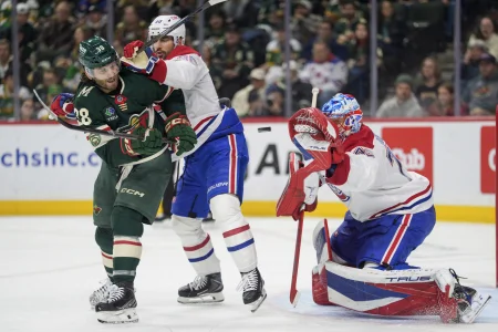 Feb 2, 2026; Saint Paul, Minnesota, USA; Minnesota Wild right wing Ryan Hartman (38) is hit by Montreal Canadiens center Joe Veleno (90) while trying to deflect a shot in the second period at Grand Casino Arena.