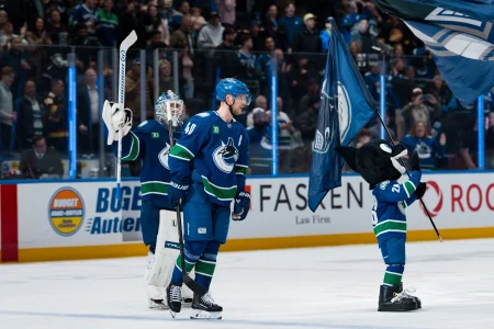 Apr 14, 2026; Vancouver, British Columbia, CAN; Vancouver Canucks goalie Kevin Lankinen (32) and forward Elias Pettersson (40) and a small mascot celebrate the Canucks victory against the Los Angeles Kings at Rogers Arena.