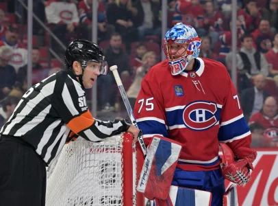 26 mars 2026; Montréal, Québec, Canada; Le gardien des Canadiens de Montréal, Jakub Dobes (75), discute avec larbitre Jake Brenk (26) durant la première période du match contre les Blue Jackets de Columbus au Centre Bell.