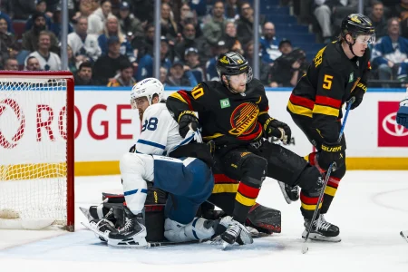 Jan 31, 2026; Vancouver, British Columbia, CAN; Vancouver Canucks defenseman Tom Willander (5) and forward Elias Pettersson (40) battle with Toronto Maple Leafs forward William Nylander (88) and goalie Joseph Woll (60) in the third period at Rogers Arena.