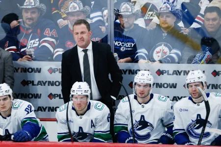 Mar 7, 2026; Winnipeg, Manitoba, CAN; Vancouver Canucks head coach Adam Foote ponders strategy against the Winnipeg Jets during the second period at Canada Life Centre.