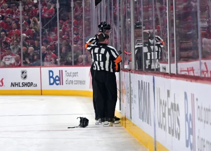 12 mai 2026; Montréal (Québec), Canada; les arbitres TJ Luxmore (21) et Kelly Sutherland (11) visionnent la reprise vidéo de la première période du quatrième match de la deuxième ronde des séries éliminatoires de la Coupe Stanley 2026 au Centre Bell.