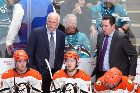 Oct 11, 2025; San Jose, California, USA; Anaheim Ducks head coach Joel Quenneville (back left) and assistant coach Jay Woodcroft (back right) stand behind the bench during the overtime against the San Jose Sharks at SAP Center at San Jose.