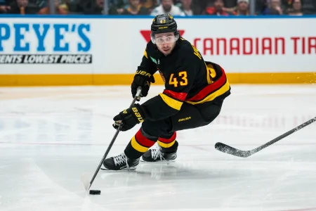 Dec 11, 2025; Vancouver, British Columbia, CAN; Vancouver Canucks defenseman Quinn Hughes (43) handles the puck against the Buffalo Sabres in the second period at Rogers Arena.
