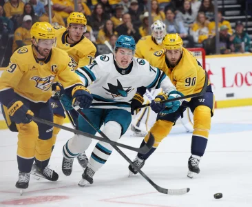 Apr 13, 2026; Nashville, Tennessee, USA; San Jose Sharks center Macklin Celebrini (71) competes for the puck against Nashville Predators defenseman Roman Josi (59) and center Ryan OReilly (90) during the third period of their game at Bridgestone Arena.