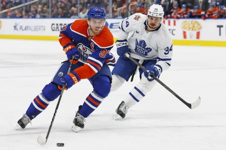Jan 16, 2024; Edmonton, Alberta, CAN; Edmonton Oilers forward Connor McDavid (97) carries the puck around Toronto Maple Leafs forward Auston Matthews (34) during the first period at Rogers Place.