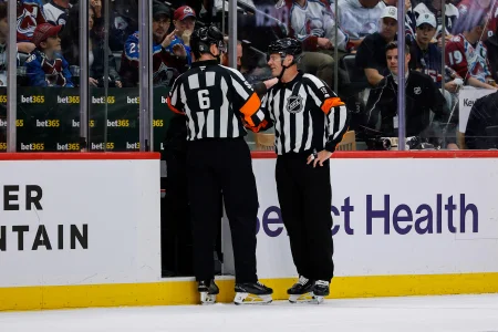 13 mai 2026 ; Denver, Colorado, États-Unis ; Larbitre Francis Charron (6) et larbitre Gord Dwyer (19) se concertent après un accrochage survenu au cours de la première période du match opposant lAvalanche du Colorado au Wild du Minnesota, dans le cadre du cinquième match du deuxième tour des séries éliminatoires de la Coupe Stanley 2026, à la Ball Arena.