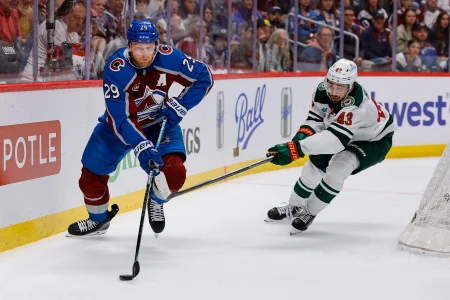 May 13, 2026; Denver, Colorado, USA; Colorado Avalanche center Nathan MacKinnon (29) controls the puck as Minnesota Wild defenseman Quinn Hughes (43) defends in the second period in game five of the second round of the 2026 Stanely Cup Playoffs at Ball Arena.