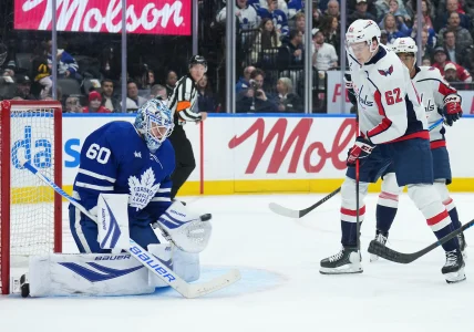 Apr 8, 2026; Toronto, Ontario, CAN; Washington Capitals left wing Ilya Protas (62) battles for the puck in front of Toronto Maple Leafs goaltender Joseph Woll (60) during the second period at Scotiabank Arena.