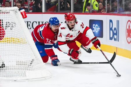 25 février 2025; Montréal, Québec, Canada; Seth Jarvis (24), centre des Hurricanes de la Caroline, garde le contrôle de la rondelle alors quil tombe sur la glace après avoir été poussé par Arber Xhekaj (72), défenseur des Canadiens de Montréal, en première période au Centre Bell.