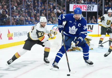 Jan 23, 2026; Toronto, Ontario, CAN; Toronto Maple Leafs center Auston Matthews (34) battles for the puck with Vegas Golden Knights defenseman Shea Theodore (27) during the third period at Scotiabank Arena.
