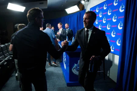 May 14, 2026; Vancouver, BC, Canada; Ryan Johnson shakes hands with a member of the media during a press conference where the Vancouver Canucks name new senior management staff. Henrik Sedin and his twin brother Daniel Sedin have been appointed as co-presidents of hockey operations and Ryan Johnson is now the new general manager of the club at Rogers Arena.