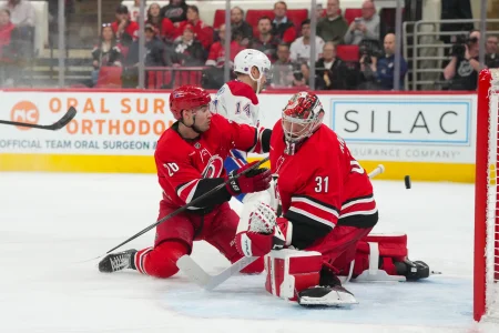 29 mars 2026 ; Raleigh, Caroline du Nord, États-Unis ; Nick Suzuki (14), centre des Canadiens de Montréal, marque un but devant le gardien des Hurricanes de la Caroline, Frederik Andersen (31), et le défenseur Sean Walker (26), en deuxième période au Lenovo Center.