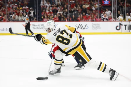 Apr 12, 2026; Washington, District of Columbia, USA; Pittsburgh Penguins center Sidney Crosby (87) shoots the puck as Washington Capitals defenseman Cole Hutson (44) defends during the second period at Capital One Arena.