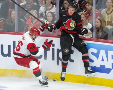 Apr 25, 2026; Ottawa, Ontario, CAN; Carolina Hurricanes defenseman Sean Walker (26) and Ottawa Senators center Tim Stutzle (18) battle for the puck in the third period of game four of the first round of the 2026 Stanley Cup Playoffs at the Canadian Tire Centre.