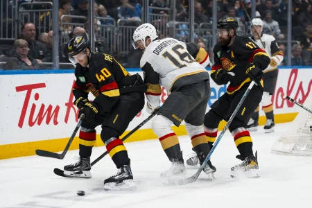 Apr 7, 2026; Vancouver, British Columbia, CAN; Vancouver Canucks forward Elias Pettersson (40) and defenseman Filip Hronek (17) battle with Vegas Golden Knights forward Pavel Dorofeyev (16) in the first period at Rogers Arena.