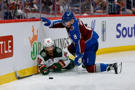 May 13, 2026; Denver, Colorado, USA; Minnesota Wild right wing Ryan Hartman (38) and Colorado Avalanche defenseman Cale Makar (8) battle for the puck in the third period in game five of the second round of the 2026 Stanely Cup Playoffs at Ball Arena.