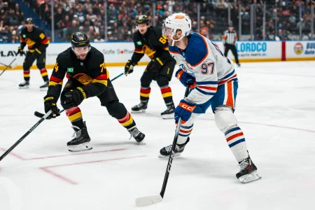 Jan 17, 2026; Vancouver, British Columbia, CAN; Vancouver Canucks forward Jake DeBrusk (74) defends against Edmonton Oilers forward Connor McDavid (97) in the third period at Rogers Arena.