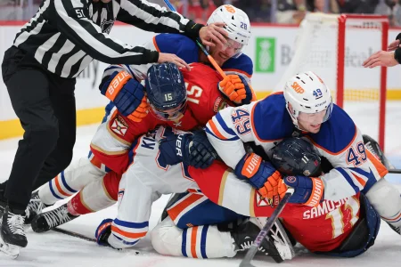 Nov 22, 2025; Sunrise, Florida, USA; Florida Panthers center Anton Lundell (15) and right wing Mackie Samoskevich (11) pile up during a scramble against Edmonton Oilers center Jack Roslovic (28) and defenseman Ty Emberson (49) during the third period at Amerant Bank Arena.