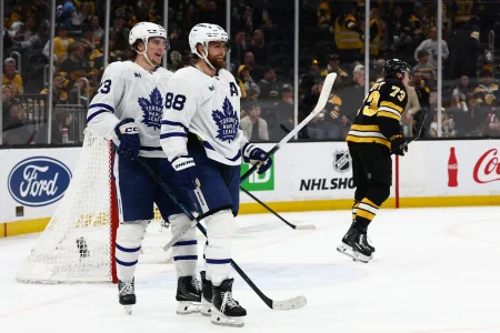 Mar 24, 2026; Boston, Massachusetts, USA; As Boston Bruins defenseman Charlie McAvoy (73) skates away, Toronto Maple Leafs right wing William Nylander (88) smiles with left wing Matthew Knies (23) after Knies scored during the third period at TD Garden