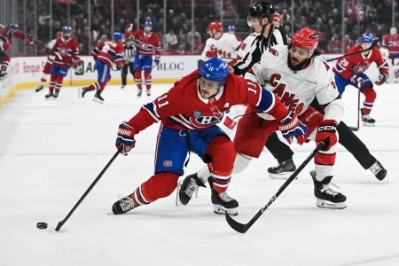 25 février 2025; Montréal, Québec, Canada; lailier droit des Canadiens de Montréal, Brendan Gallagher (11), joue la rondelle contre le défenseur des Hurricanes de la Caroline, Jalen Chatfield (5), en première période au Centre Bell.