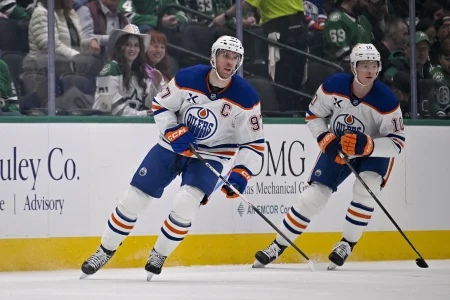 Mar 12, 2026; Dallas, Texas, USA; Edmonton Oilers center Connor McDavid (97) and center Trent Frederic (10) skates against the Dallas Stars during the game between the Stars and the Oilers at the American Airlines Center.